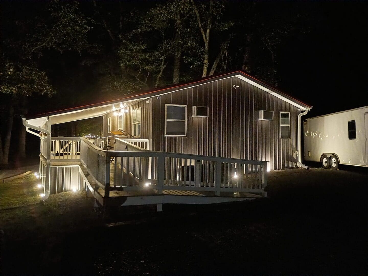Modern house with ramp lit at night.