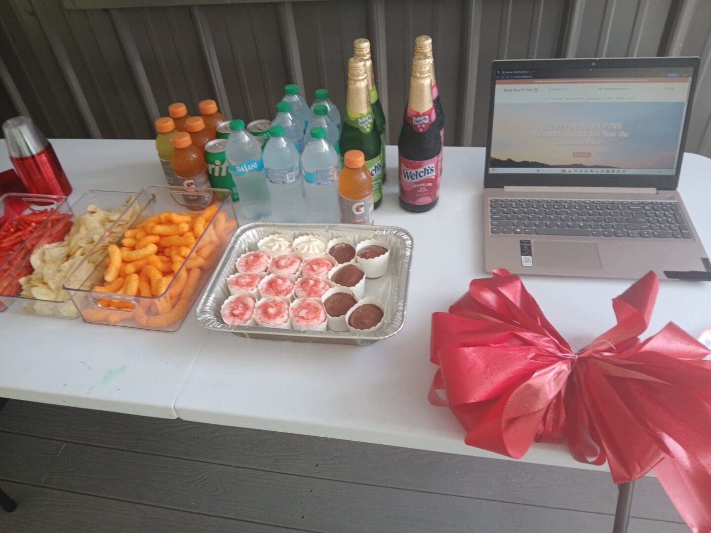 Snack table with laptop and drinks.