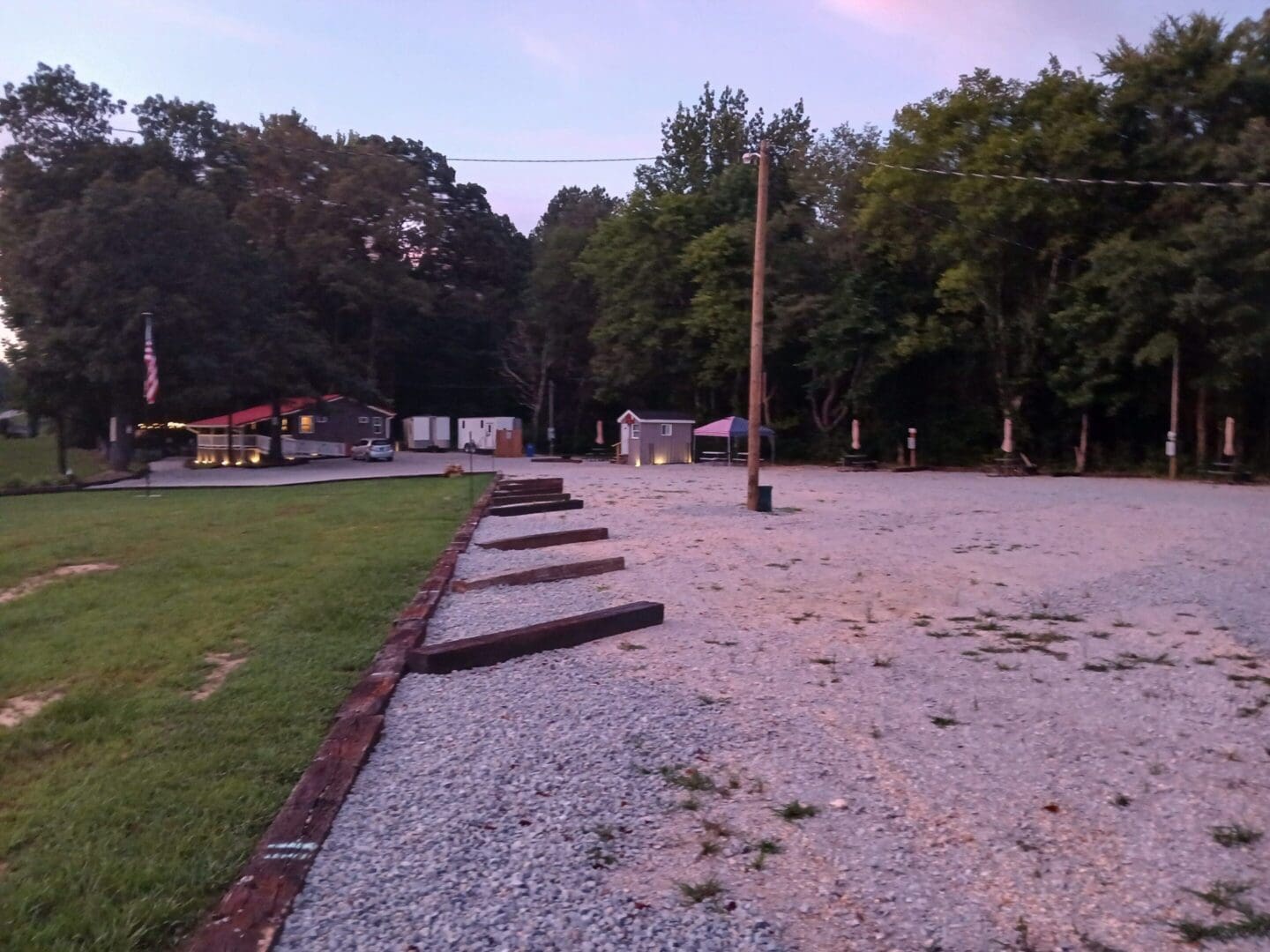 Gravel parking lot near trees and buildings.