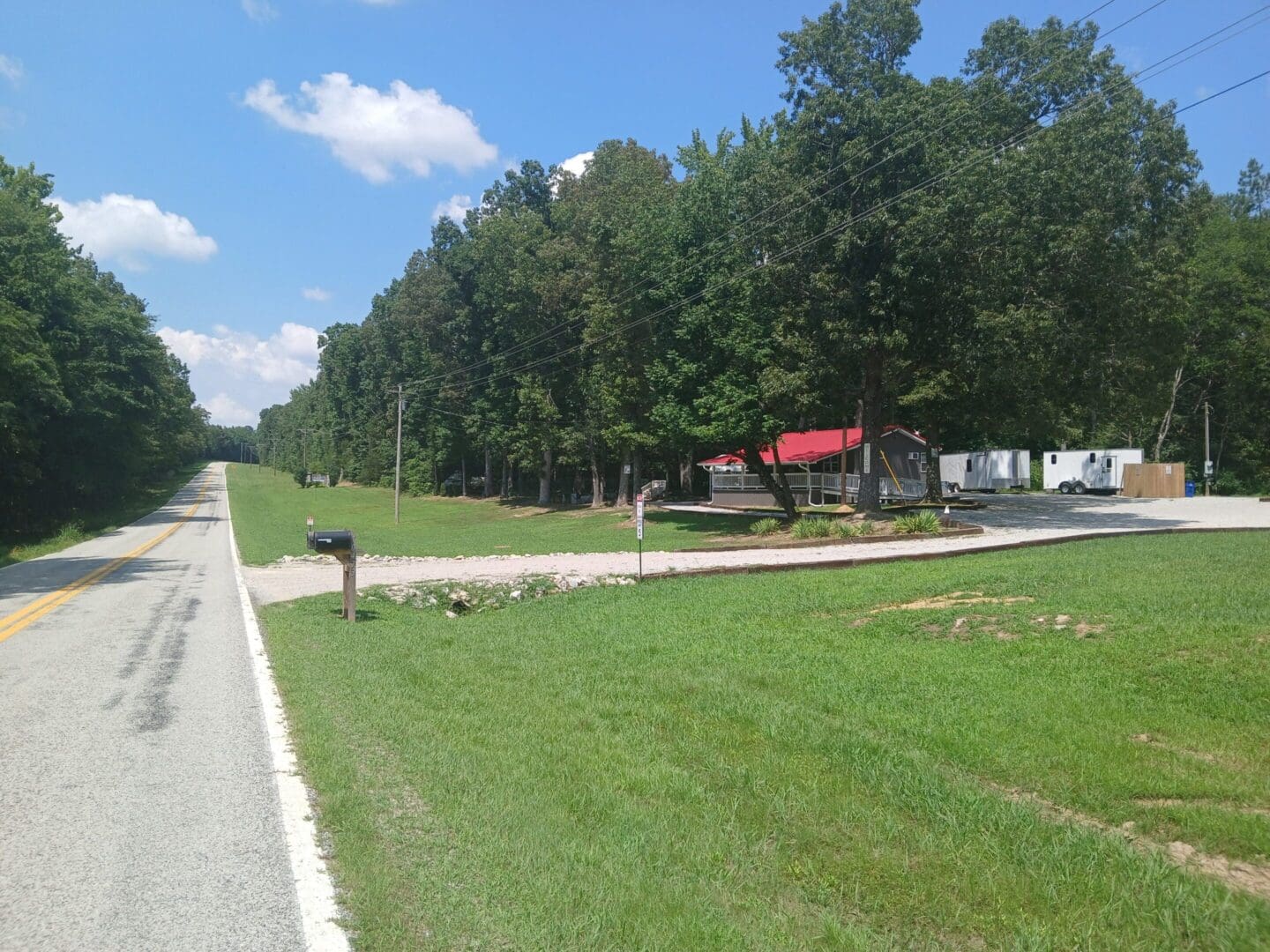 Rural road with trees and buildings.