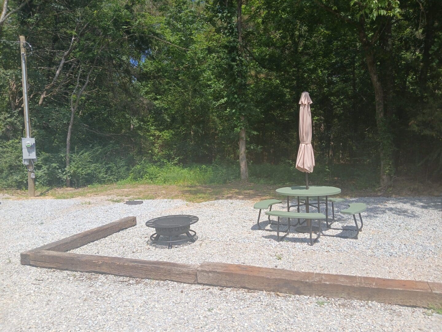 Outdoor seating area with fire pit and umbrella.