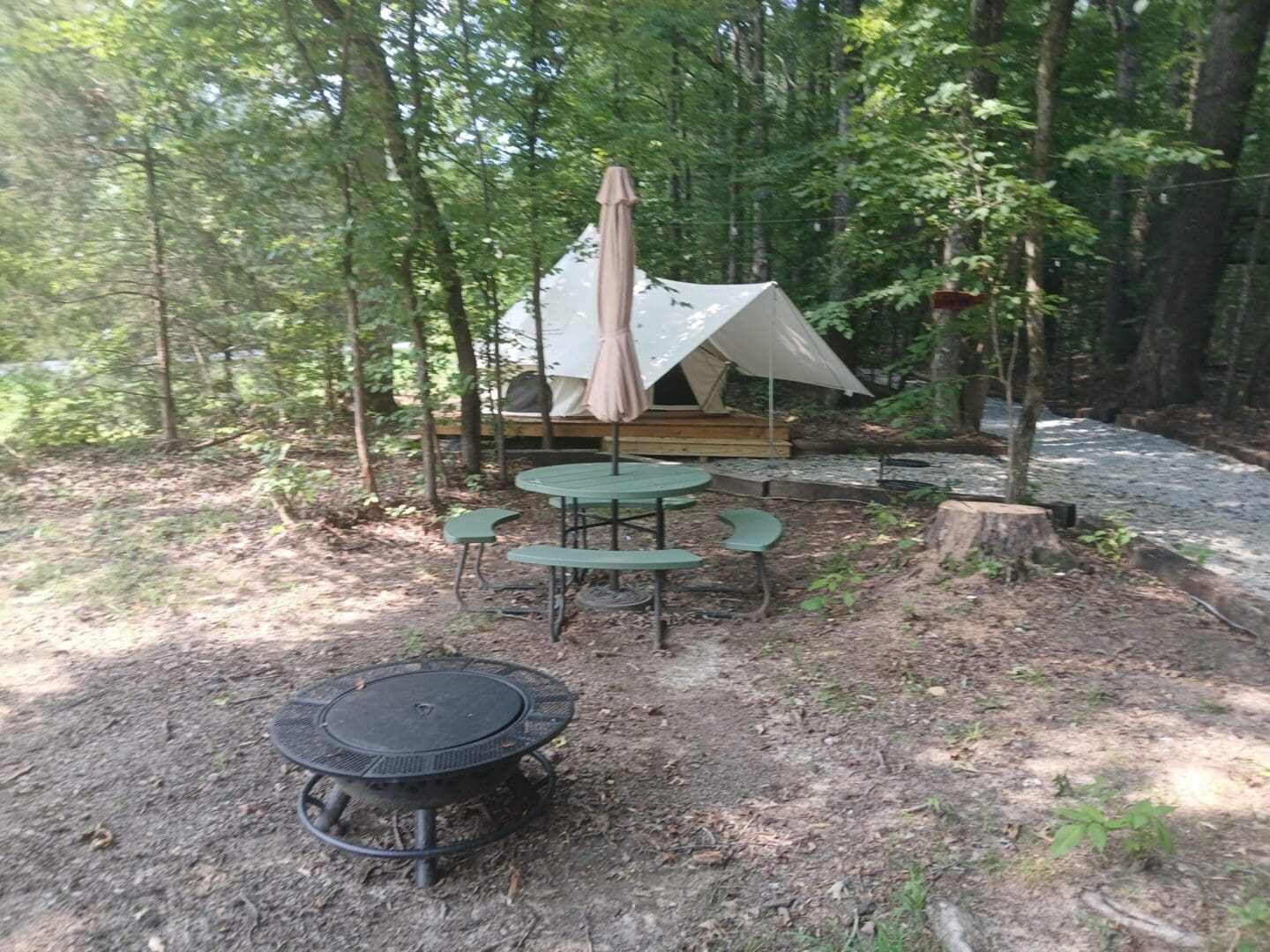 Campsite with tent, table, and fire pit.