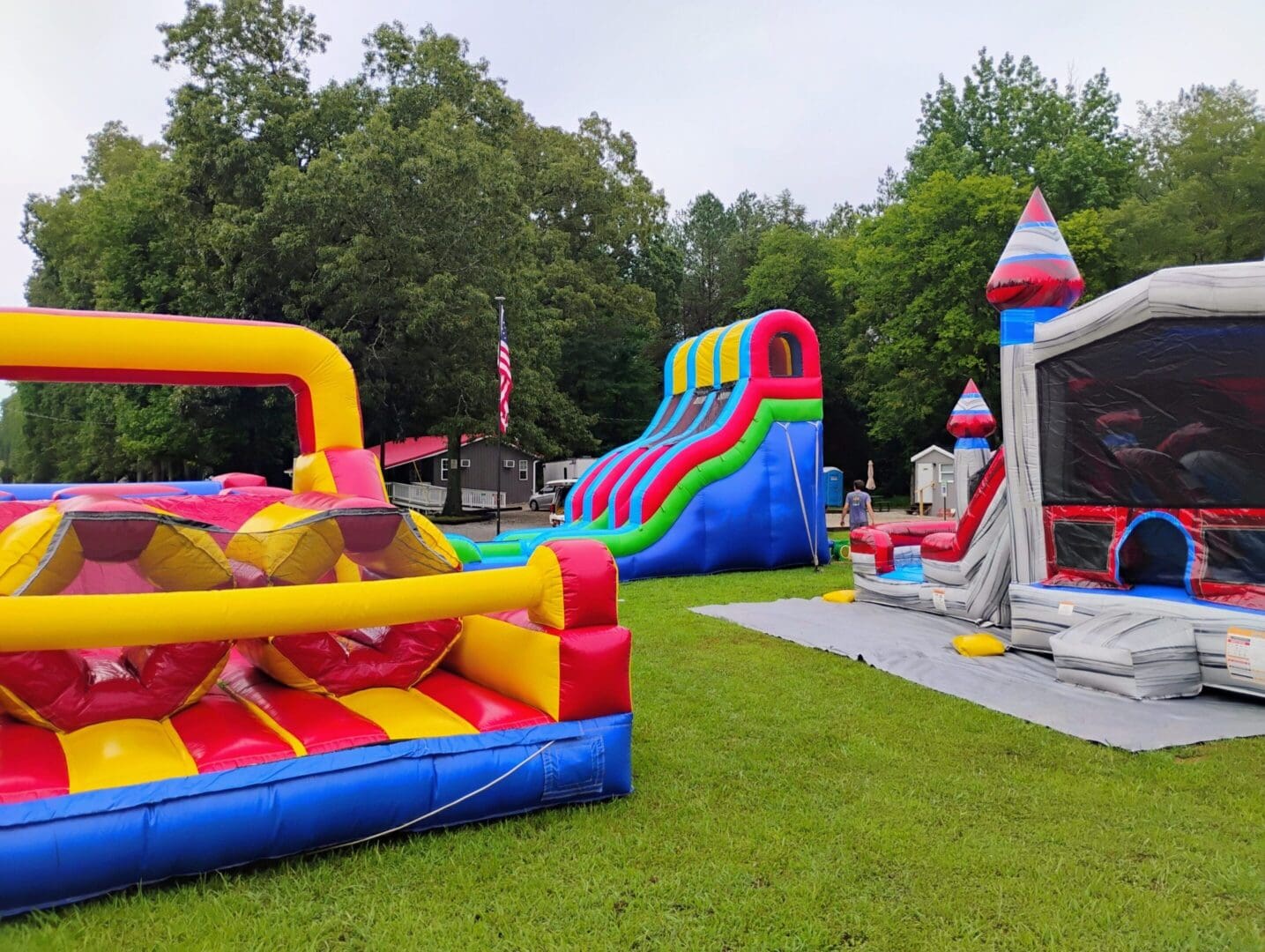 Colorful inflatable bounce houses and slide outdoors.