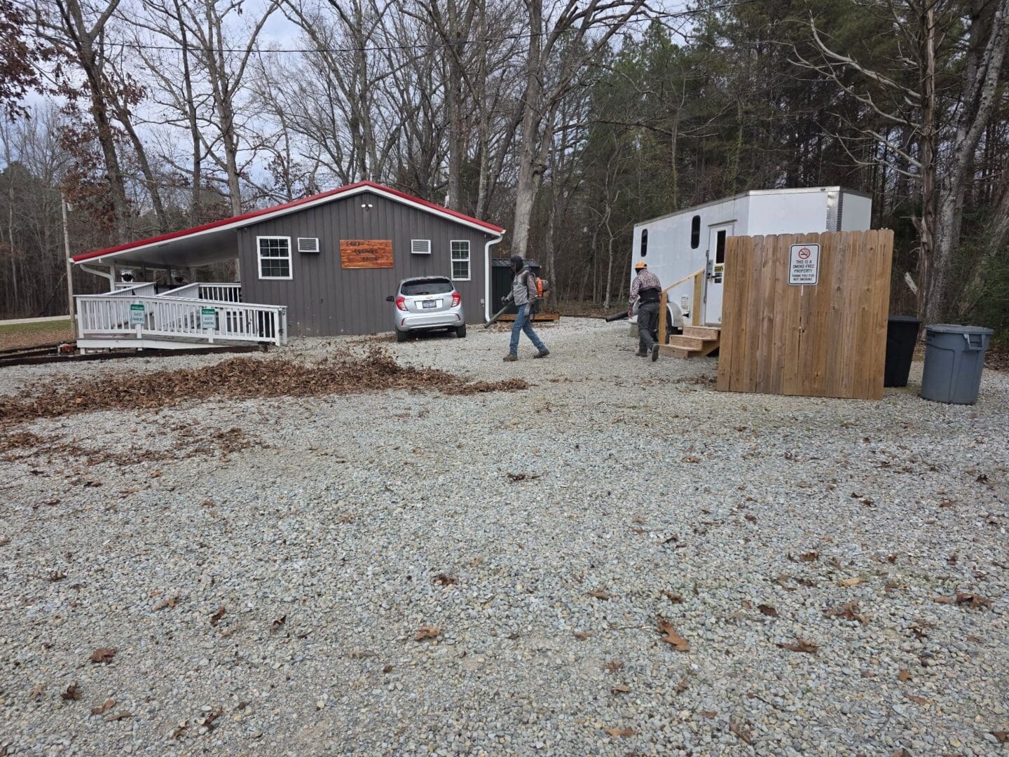 People walking near a gray cabin.