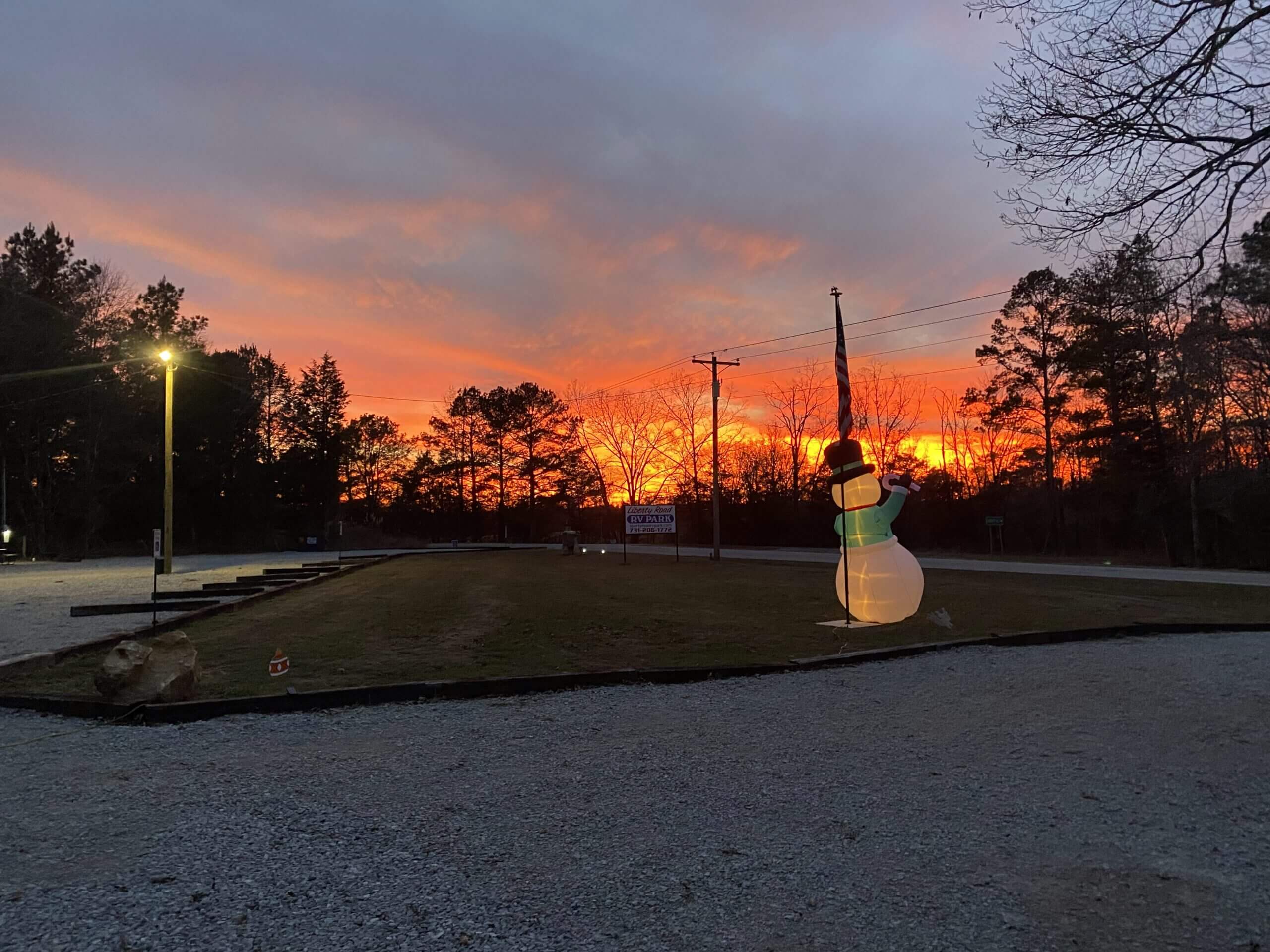 Sunset sky with inflatable snowman decoration.