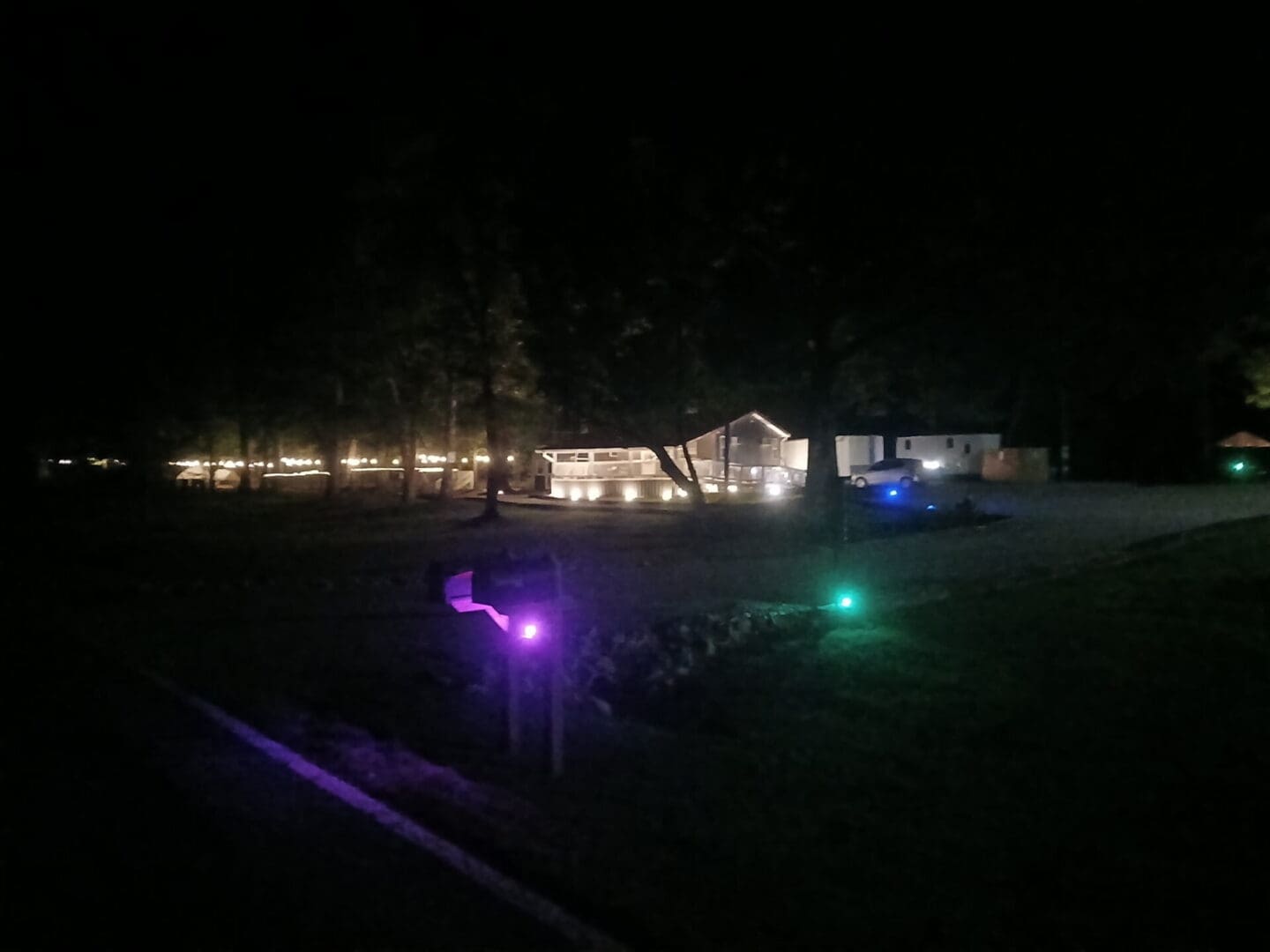 House and yard illuminated by colorful outdoor lights