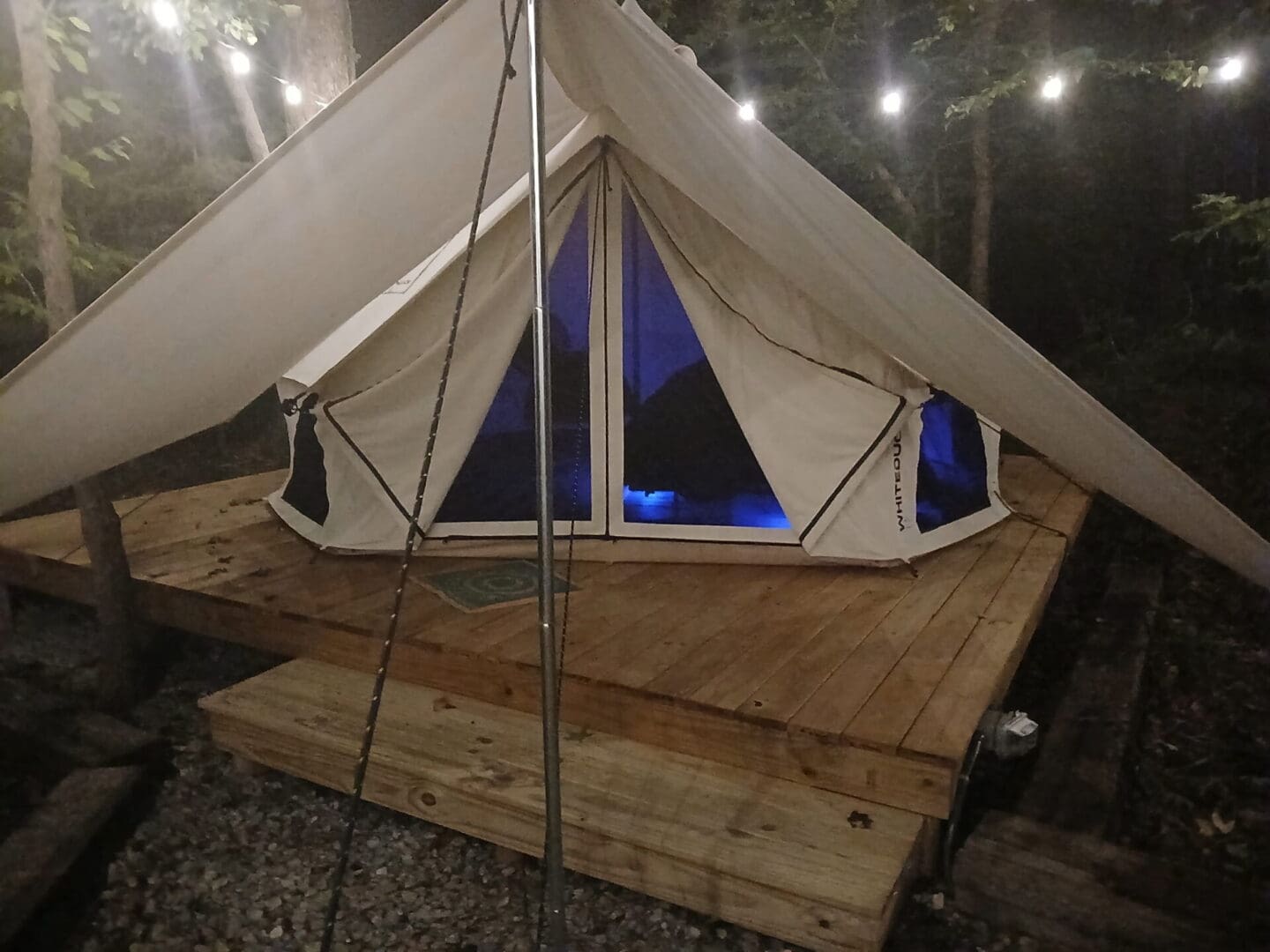 Canvas tent on wooden platform with blue light