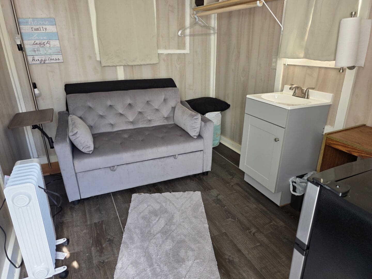 Small room with gray loveseat and sink