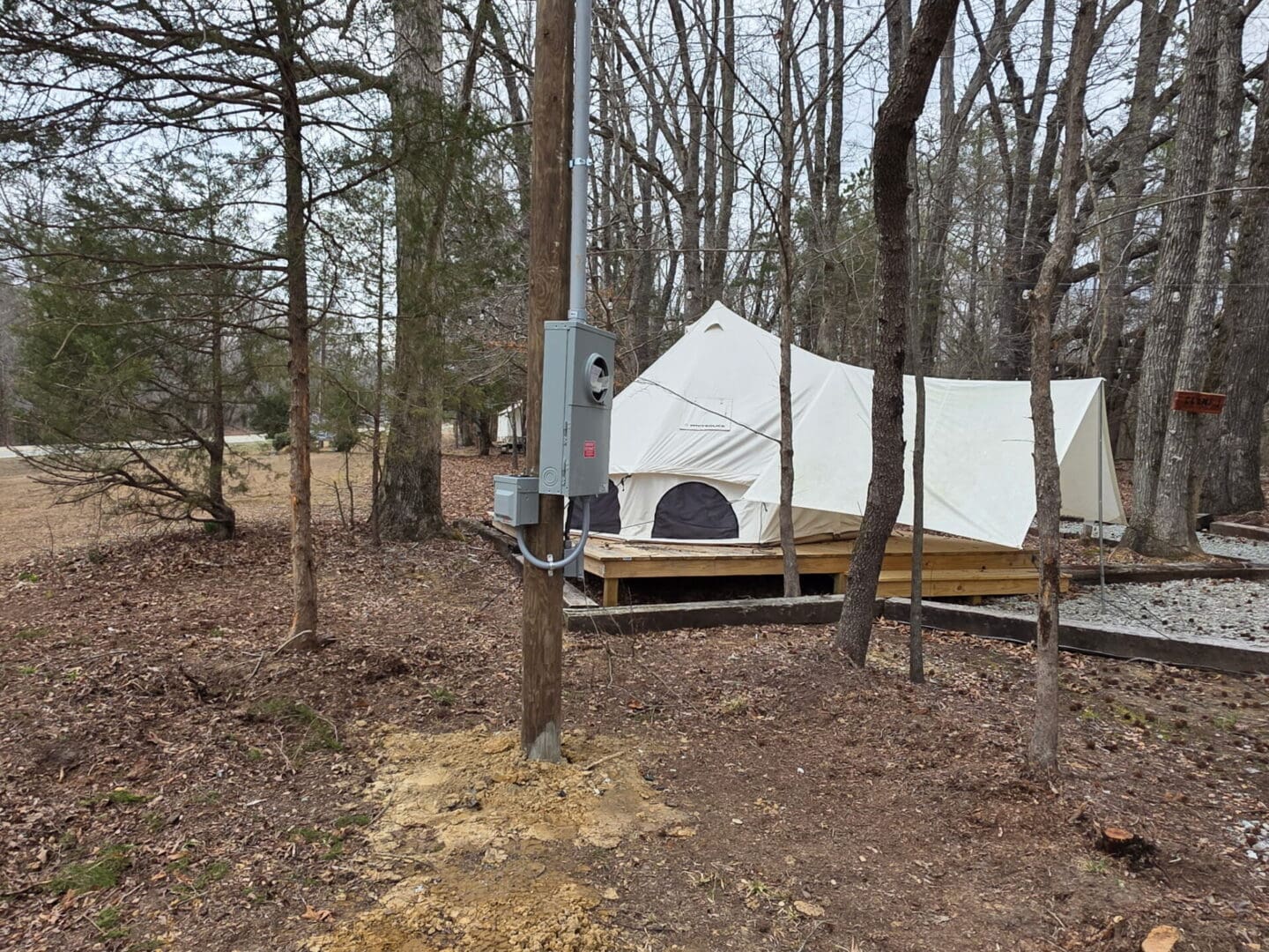 Canvas tent on platform next to utility pole