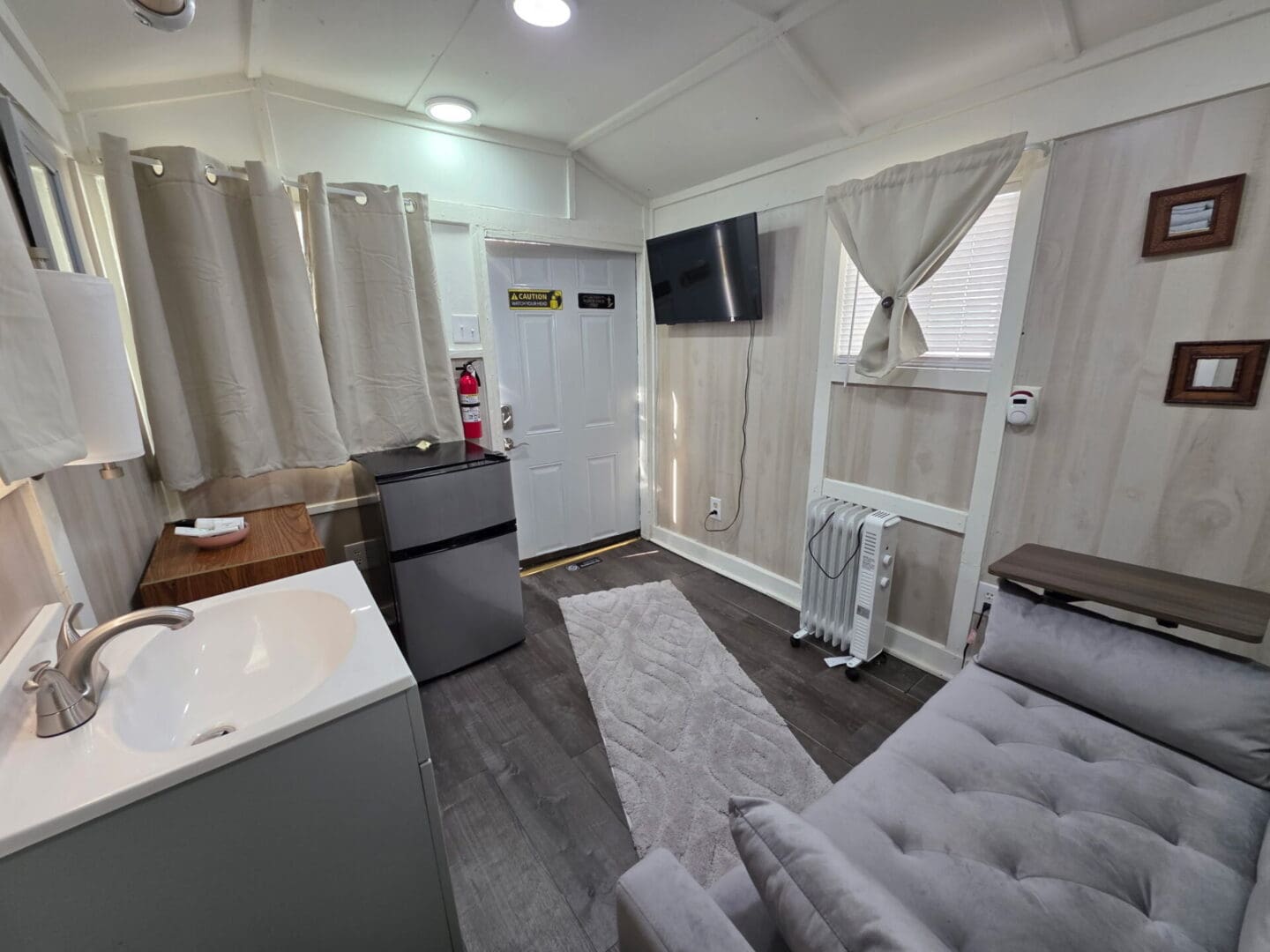 Small studio interior with sofa, sink, and TV