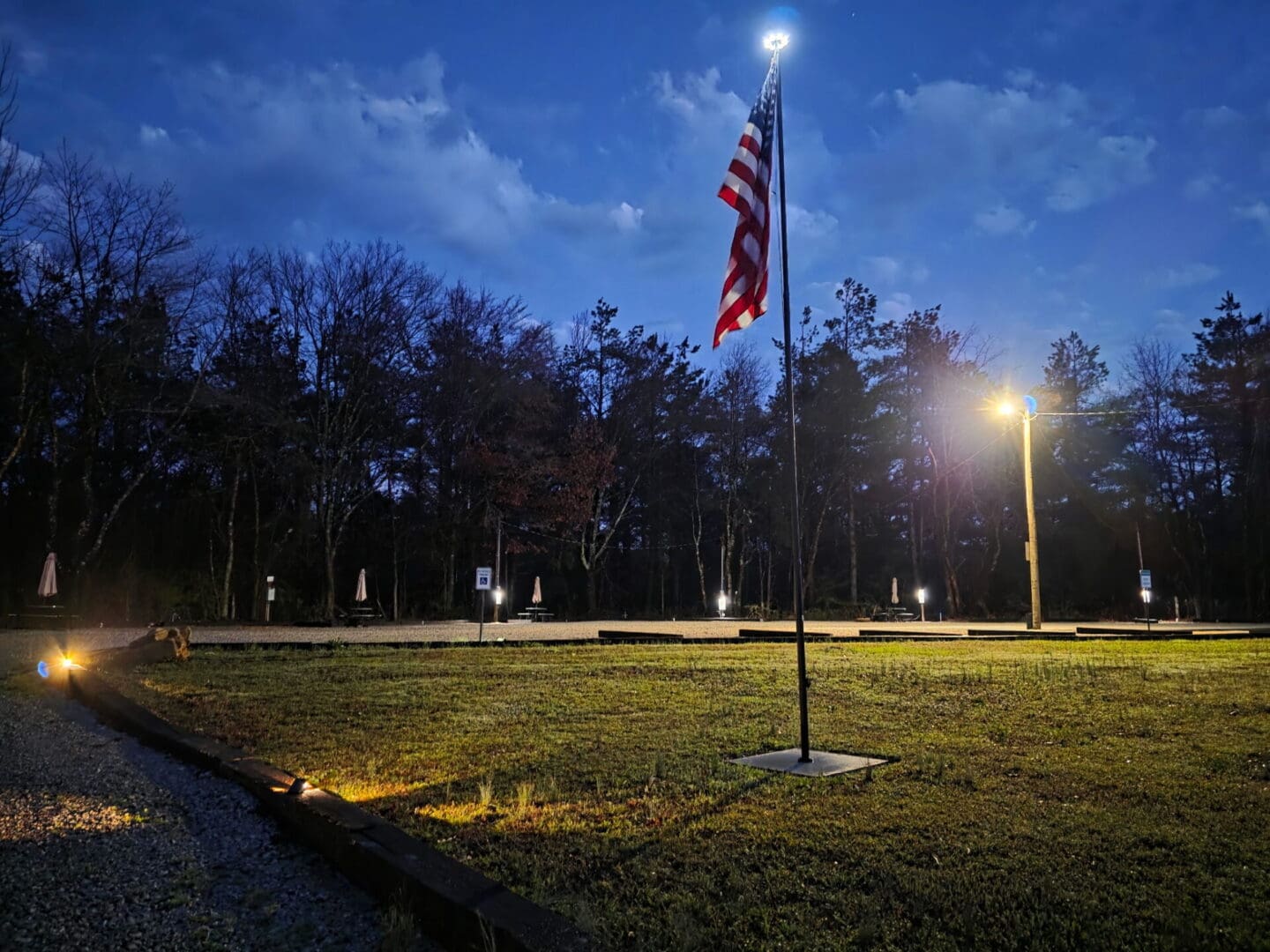 American flag illuminated at night in park