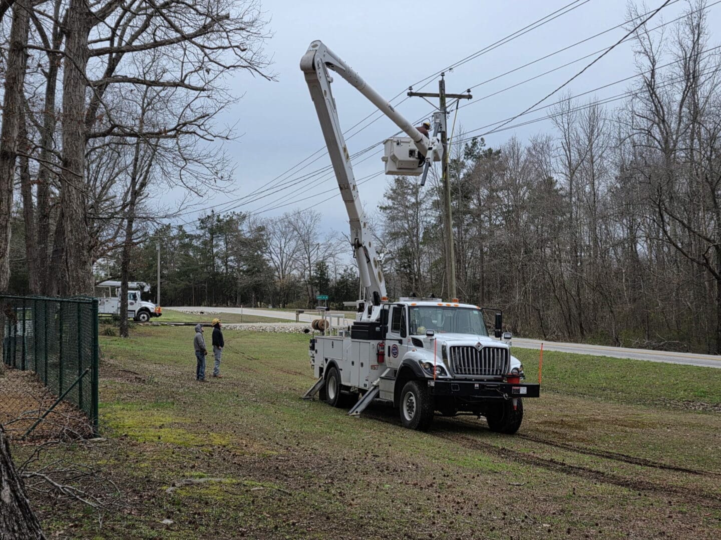 Utility crew and bucket truck near road
