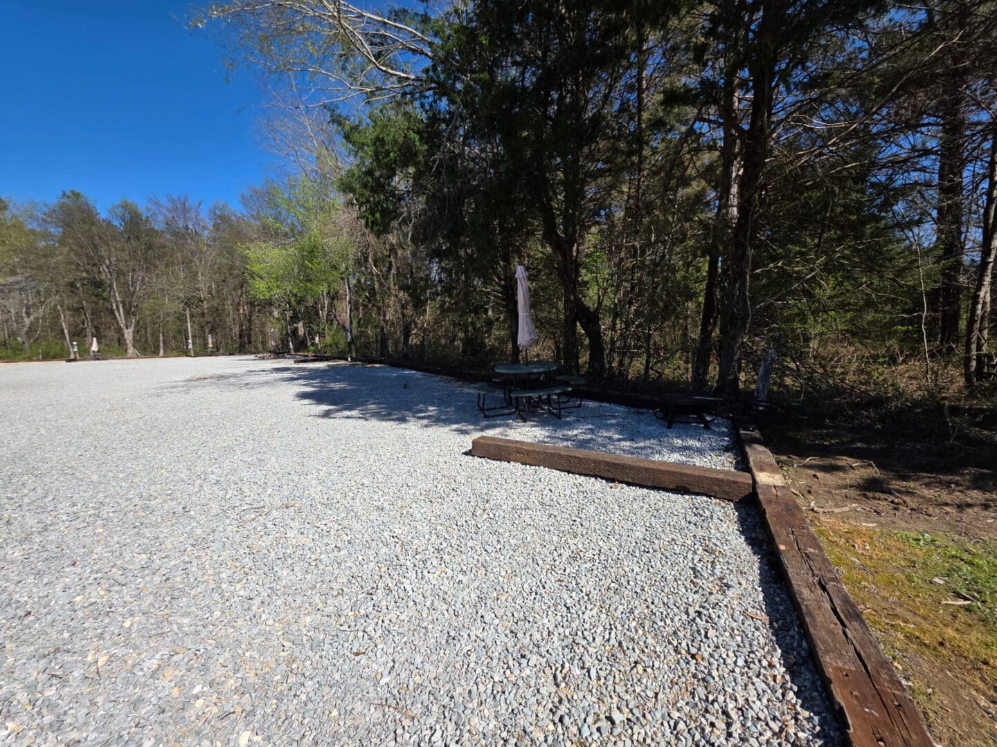 Gravel lot with picnic table under trees