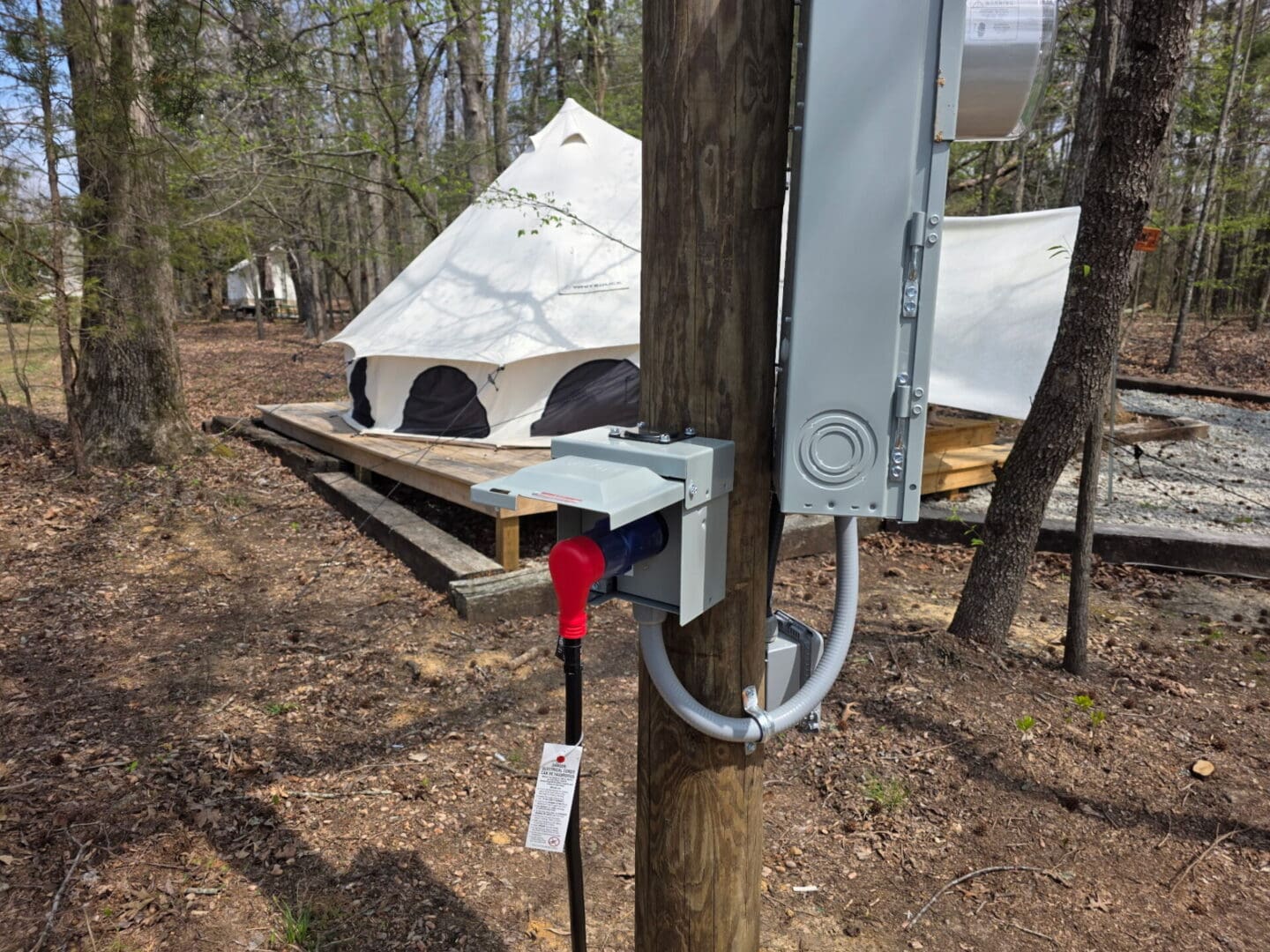 White canvas tent near electrical hookup post