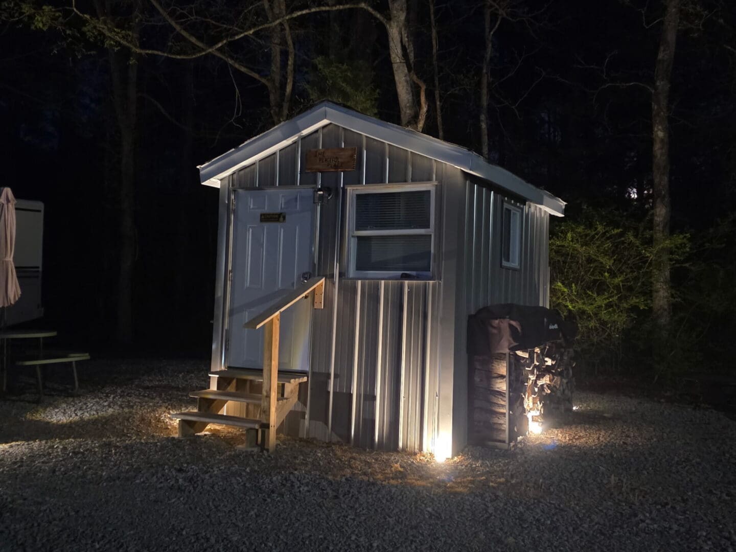 Night-lit shed with stacked firewood