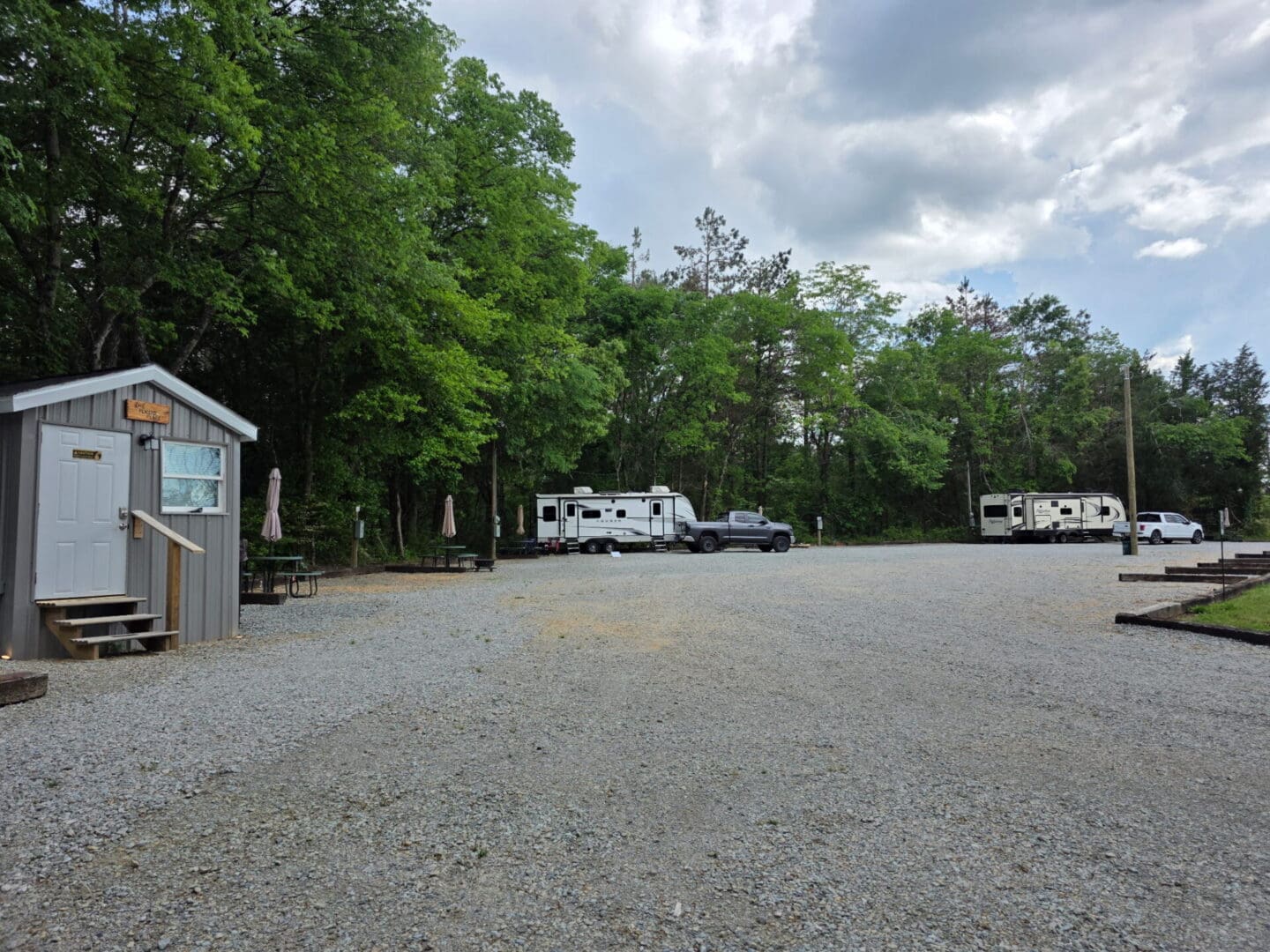 Gravel RV campground with trailers and trees