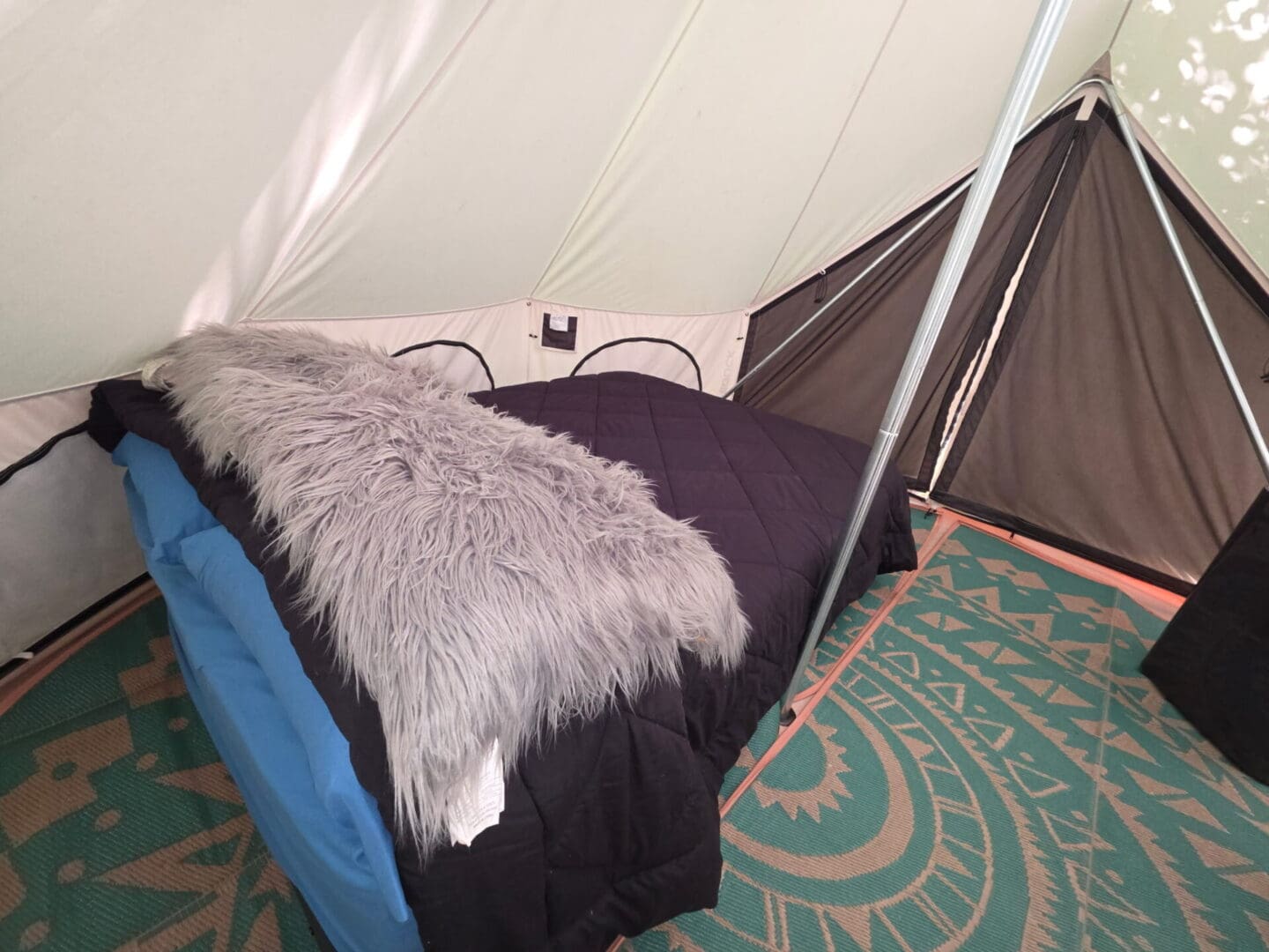 Cozy bed setup inside a camping tent