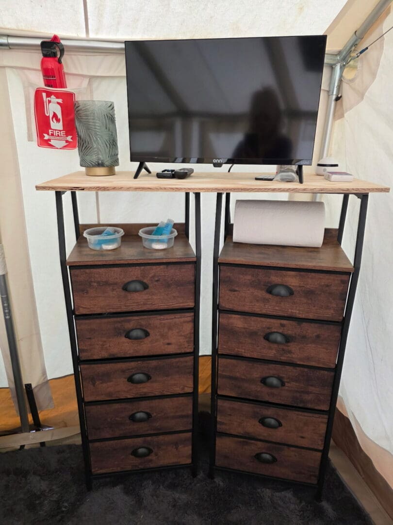 TV atop twin wooden drawer cabinets